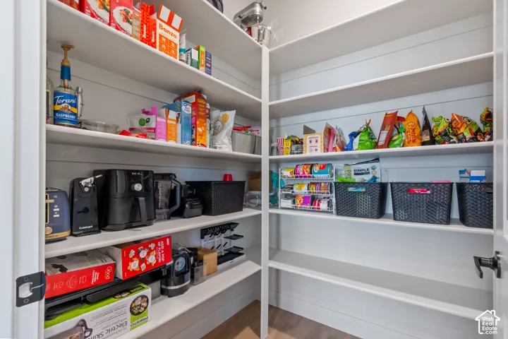 Spacious pantry with extensive shelving and shiplap-style walls