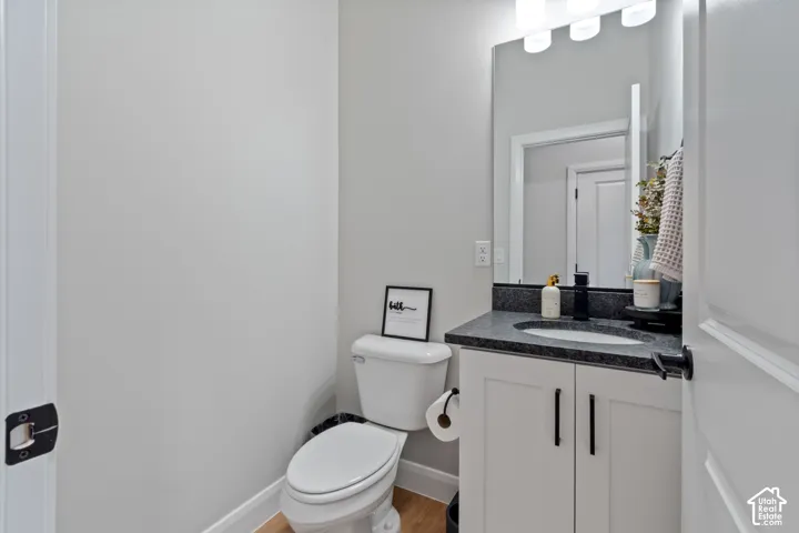 White vanity with dark hardware, stone-finish countertop, and undermount sink
