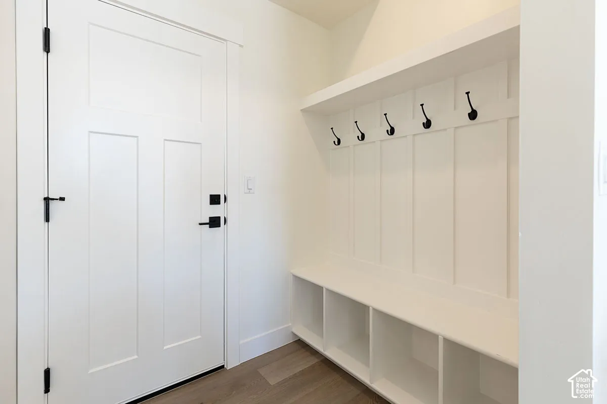 Built-in mudroom bench with cubbies, shaker-style door, and wood-finish flooring