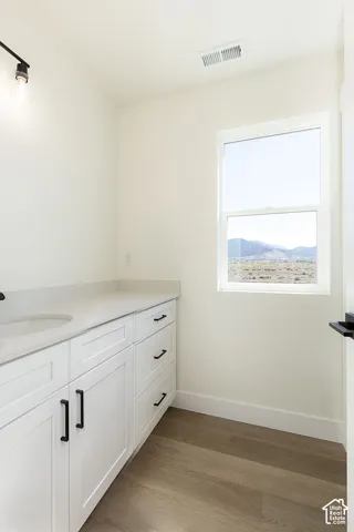 White vanity with integrated sink, light-toned countertop, and black hardware