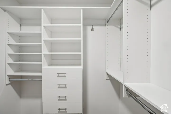 Built-in closet system featuring white shelving, four drawers with brushed nickel hardware, and multiple hanging rods