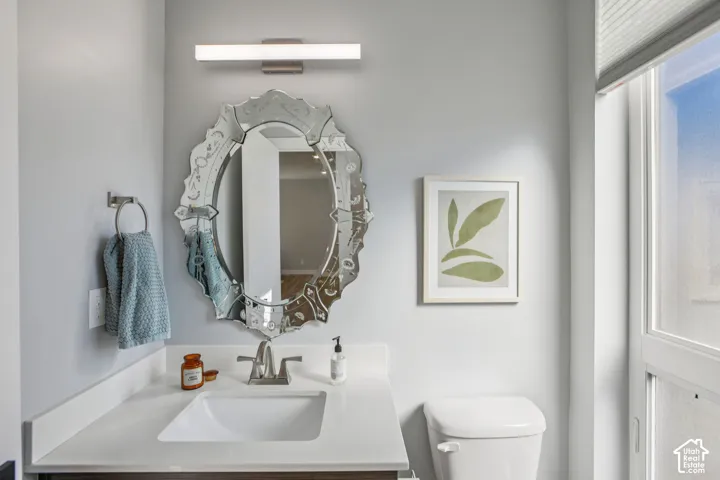 White rectangular sink with brushed nickel faucet, light-colored countertop, and decorative framed mirror