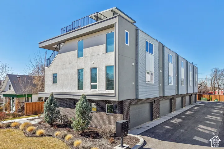 Contemporary multi-level facade with a flat roofline and integrated rooftop balcony
