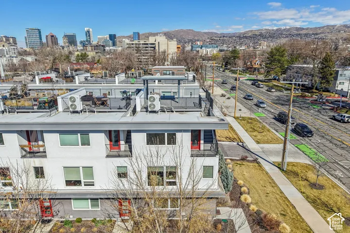 Rooftop terrace with black railings, a cityscape backdrop, and distant mountains