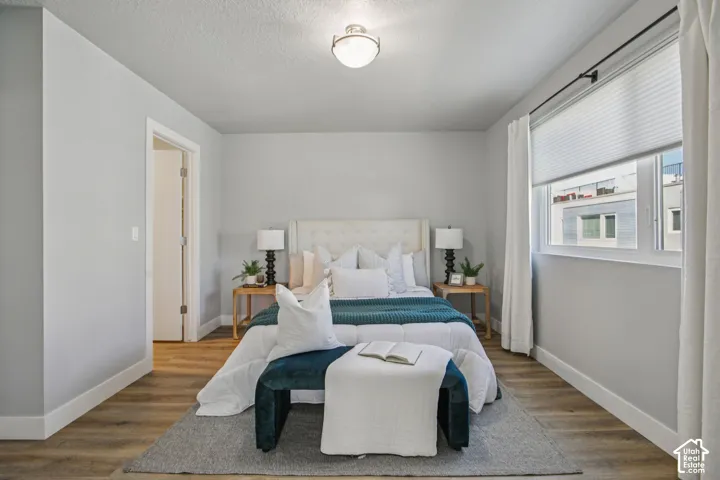 Recessed lighting, wood-finish flooring, white window treatments, and a built-in overhead light fixture