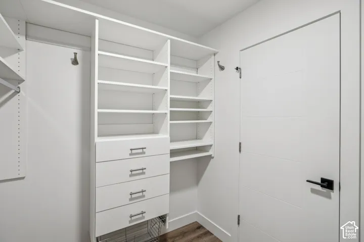 Built-in closet system featuring multiple shelving units, integrated drawers with brushed nickel pulls, and a wire basket