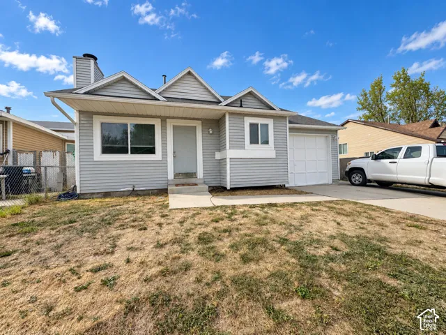Light gray siding exterior with white trim, attached garage, front entryway, and concrete driveway