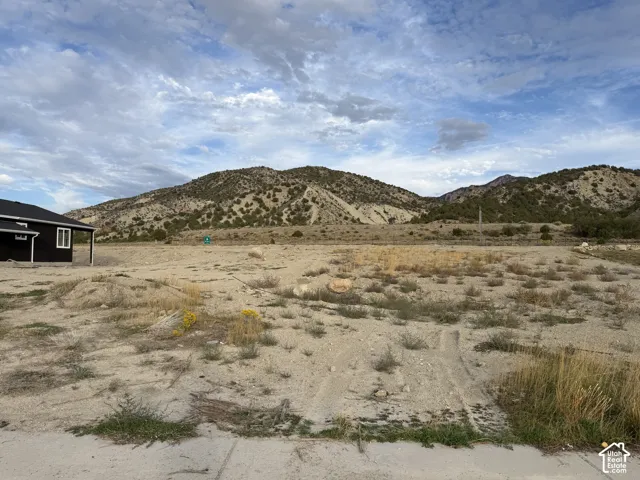 Expansive, undeveloped lot featuring a natural, arid landscape with distant mountain topography