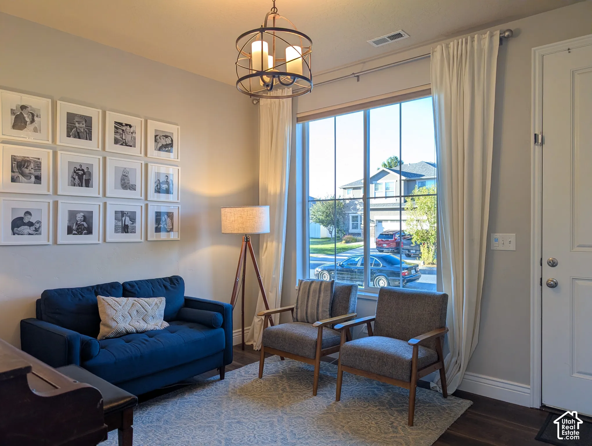 Large window with white trim, dark wood-finish flooring, and a white paneled door