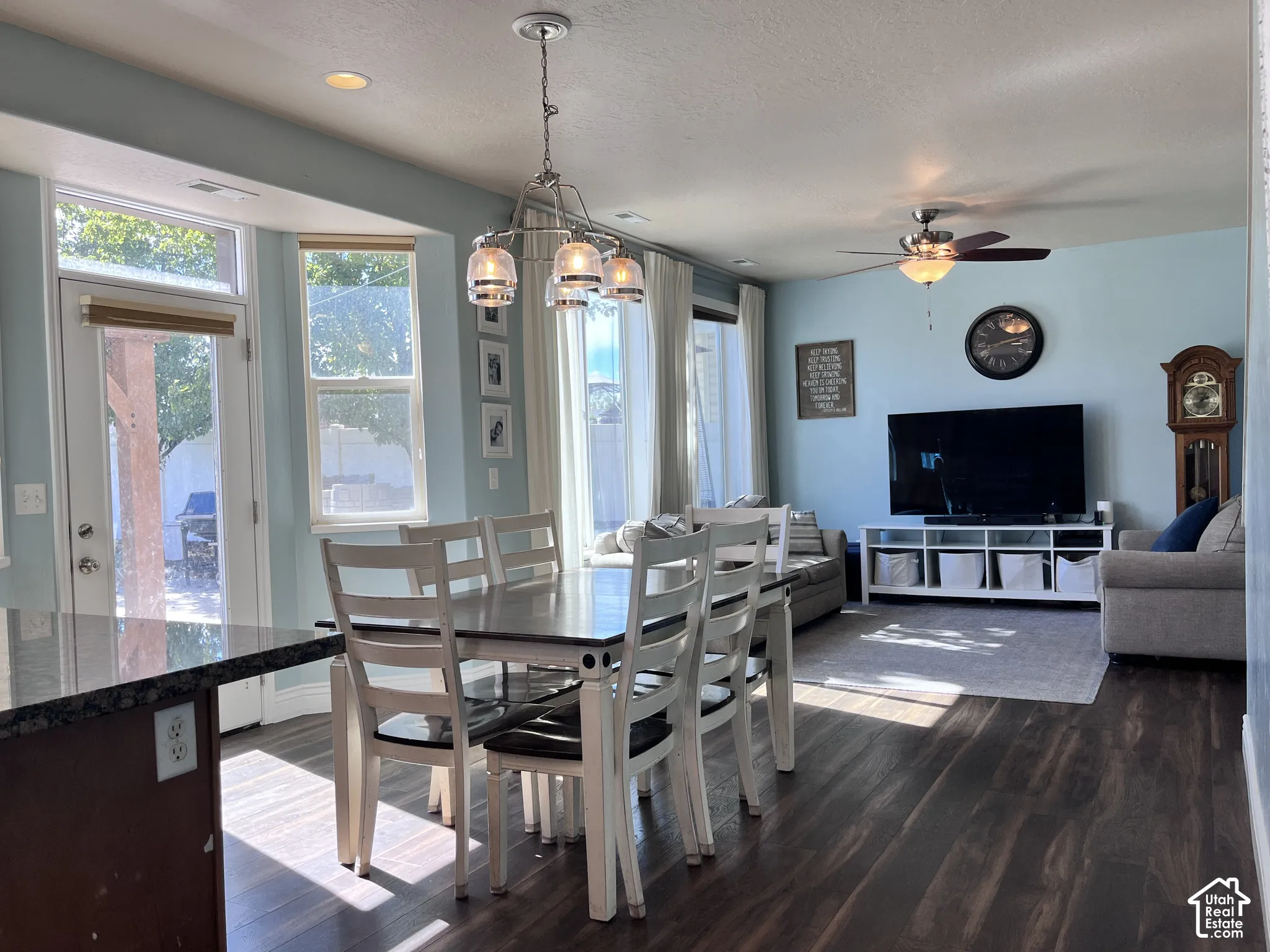 Open-concept living space featuring wood-finish flooring, recessed lighting, and a multi-light pendant fixture