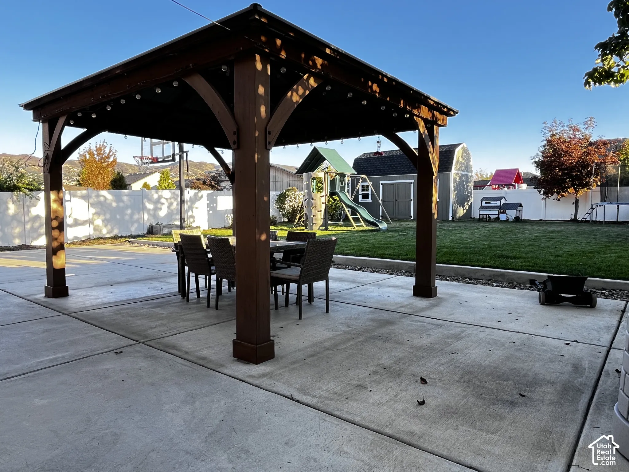 Concrete patio with an overhead pergola featuring string lighting