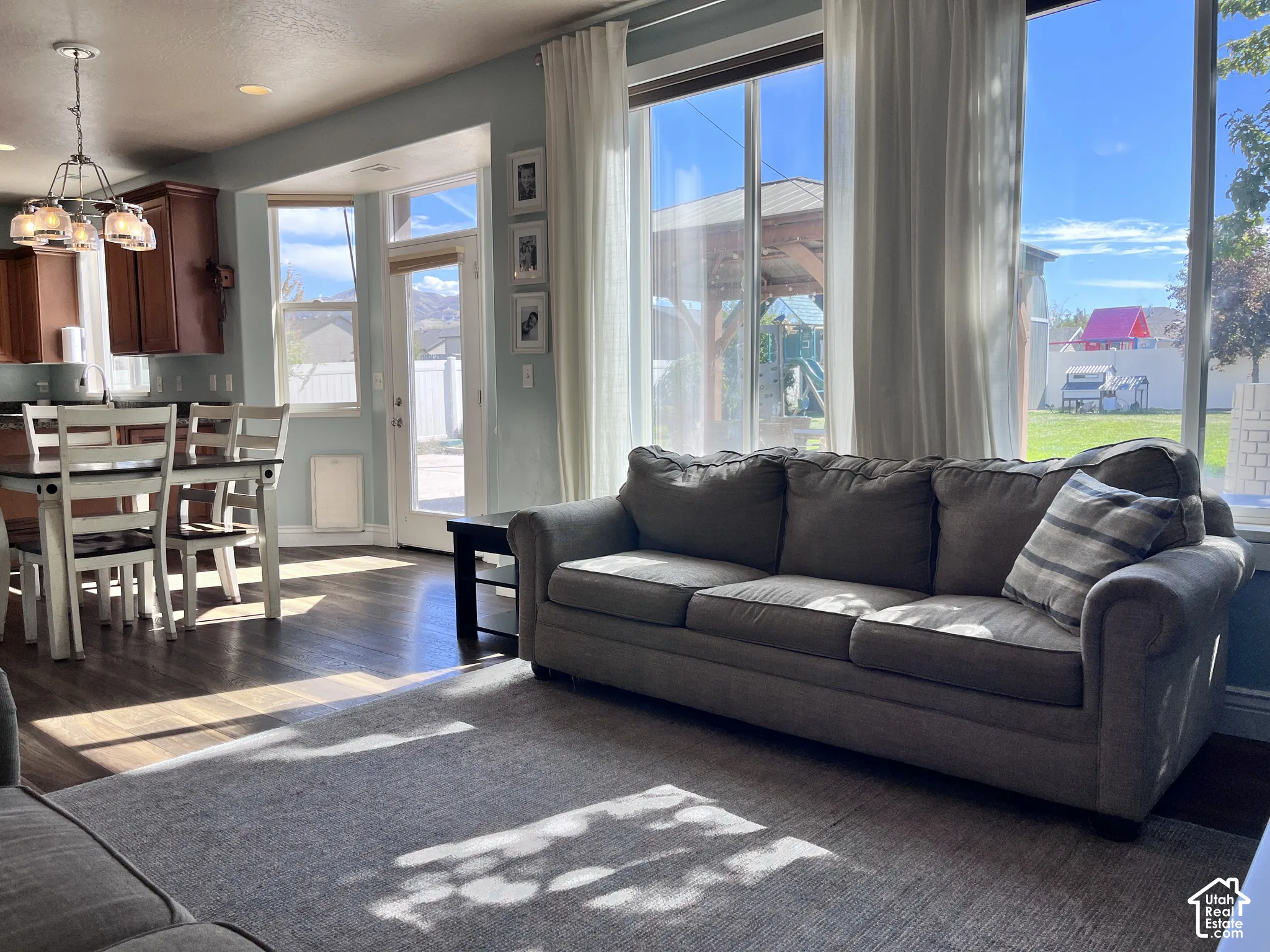 Hardwood-finish flooring, built-in cabinetry, pendant light fixture, abundant natural light, and a backyard area