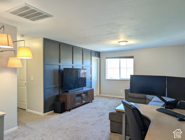 Accent wall with panel molding, carpeted flooring, window with grid panes, flush mount ceiling light, and recessed lighting