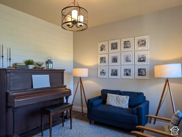 Shap-lap accent wall, contemporary chandelier, and dark wood-finish flooring