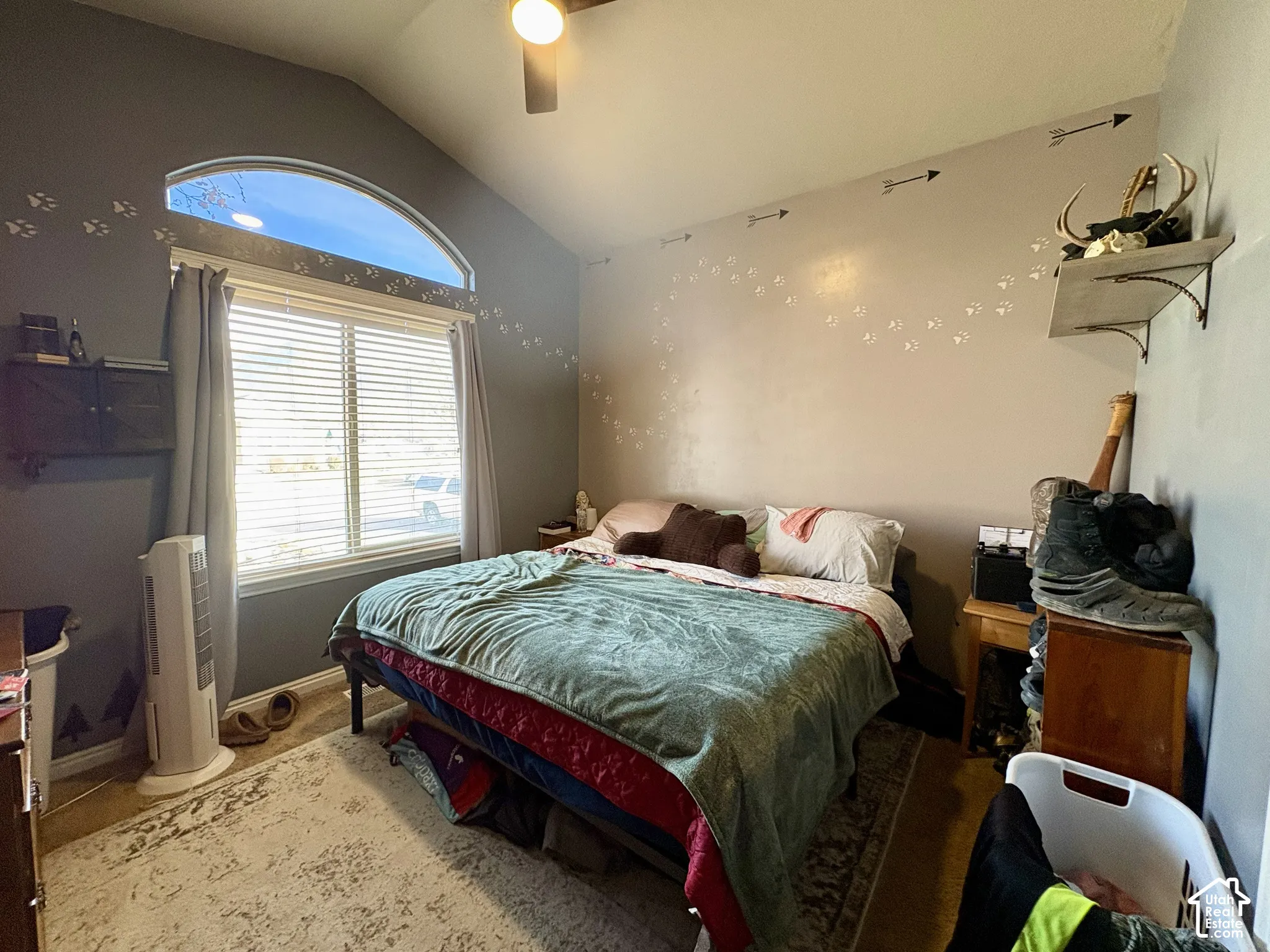 Vaulted ceiling with a ceiling fan, arched transom window, and a window with blinds