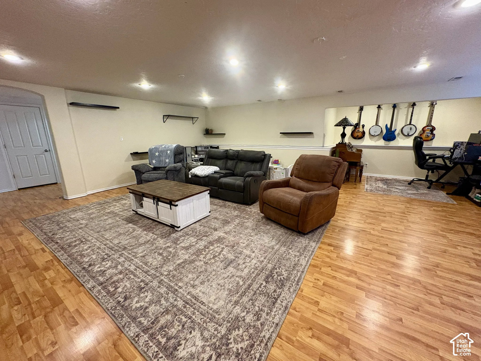 Wood-finish flooring throughout, recessed lighting, and wall-mounted shelving