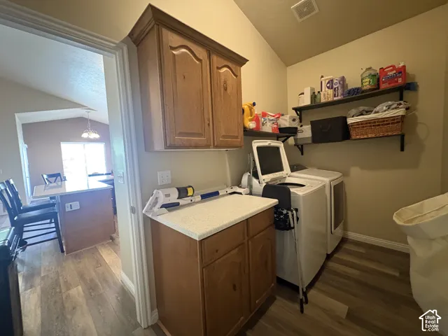 Laundry area featuring wood-finish flooring, built-in cabinetry, and wall-mounted shelving