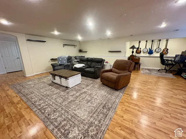 Wood-finish flooring throughout, recessed lighting, and wall-mounted shelving