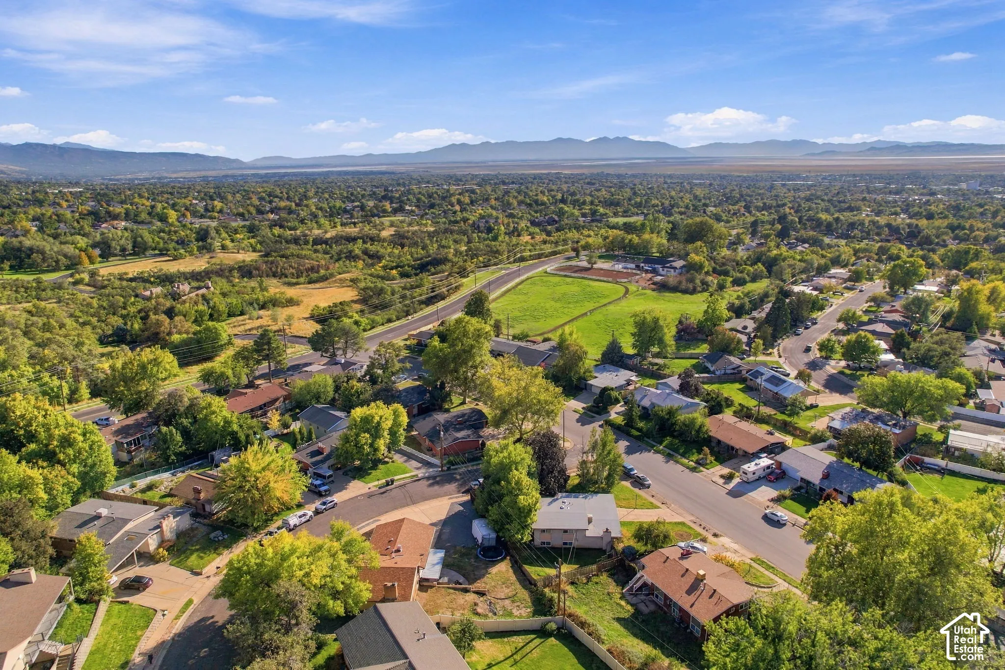 Expansive residential area featuring established homes, mature trees, and a distant mountain range