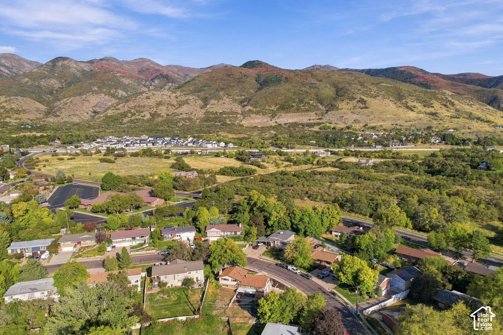 Expansive mountainous landscape framing a residential neighborhood with varied architecture and mature trees