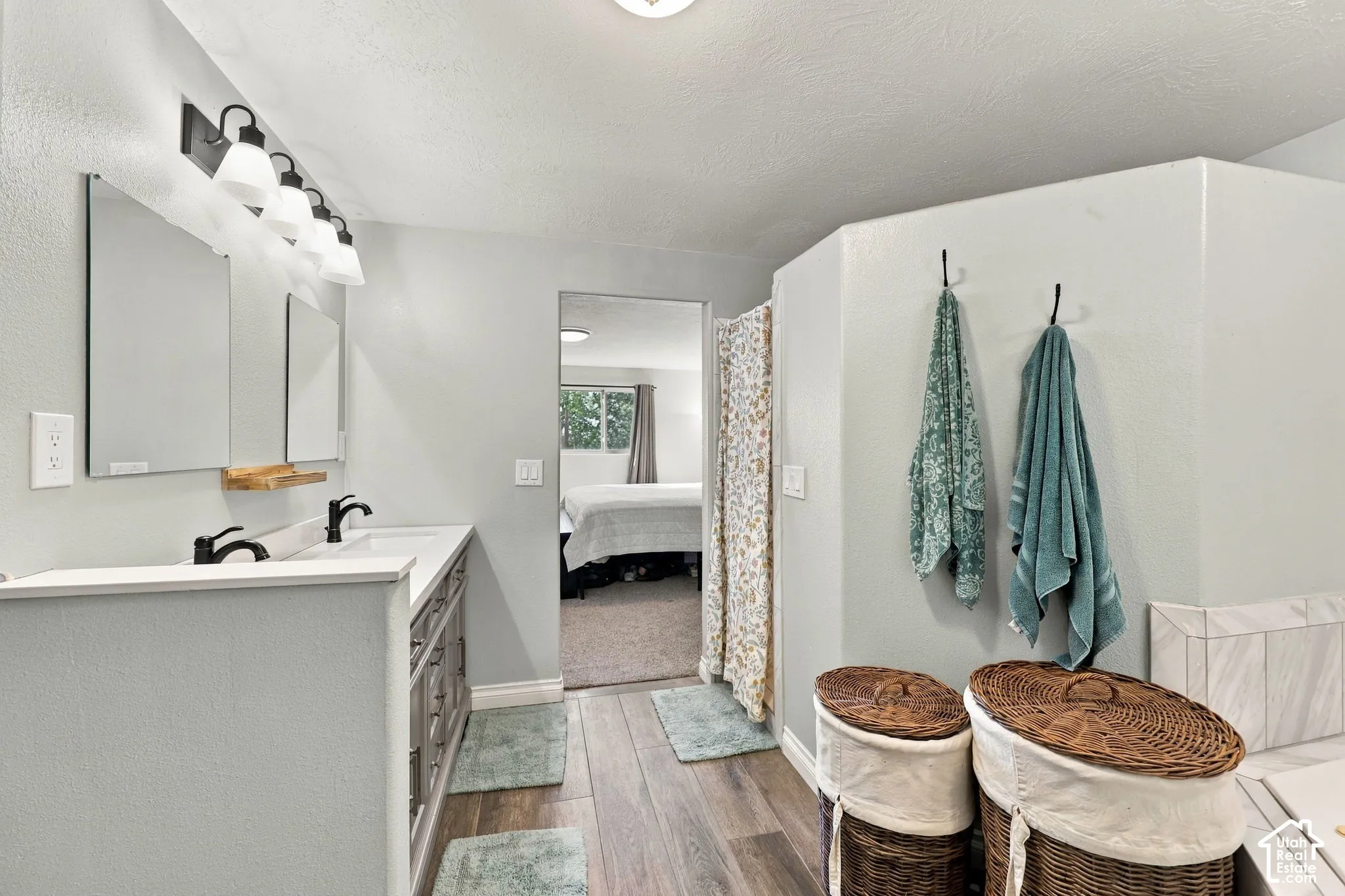Dual vanity in primary suite bathroom with separate tub and shower