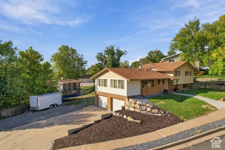 Single family residence featuring a two-car garage, concrete driveway, and a paved walkway