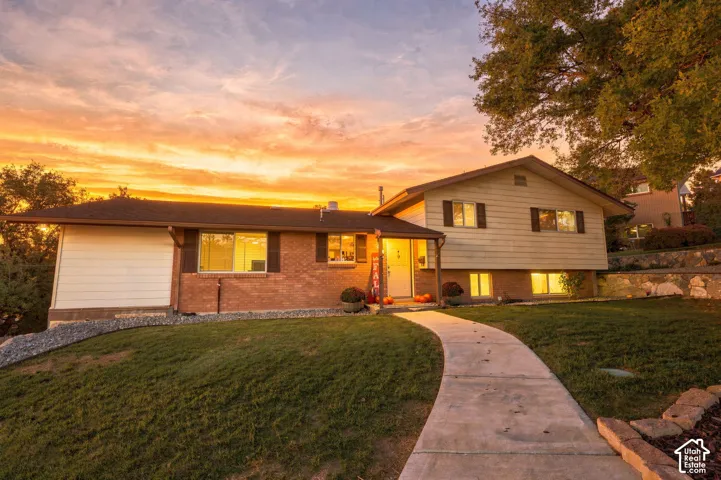 Exterior view of single family home, brick and siding facade, covered front entry, attached garage, and a concrete walkway