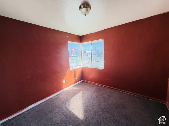 Corner windows, ceiling-mounted light fixture, and carpeted flooring