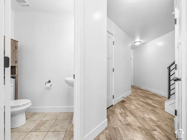 Half bathroom with pedestal sink and tiled flooring