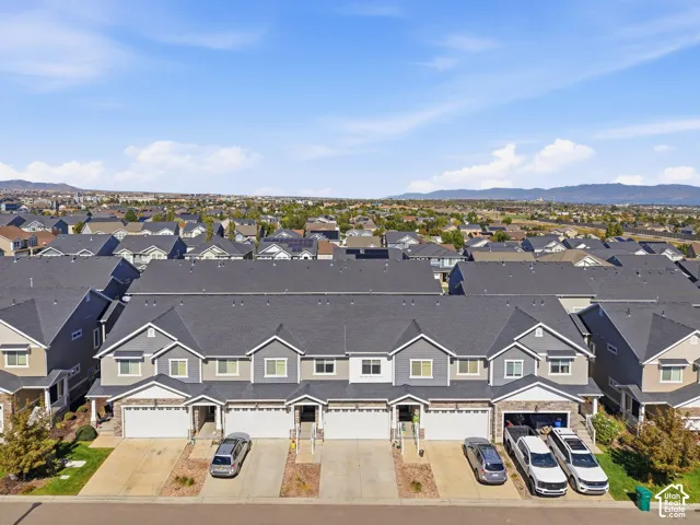 Townhome exterior with two-car garage, stone facade accents, and a landscaped front yard