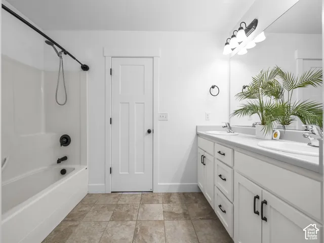 Dual sink vanity with white cabinetry, square undermount sinks, and chrome faucets