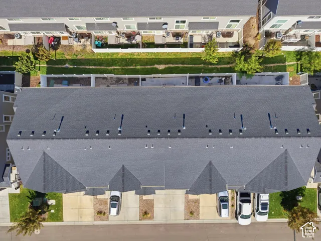 Gray shingle roofing with multiple ventilation fixtures, concrete driveways, and landscaped front yards