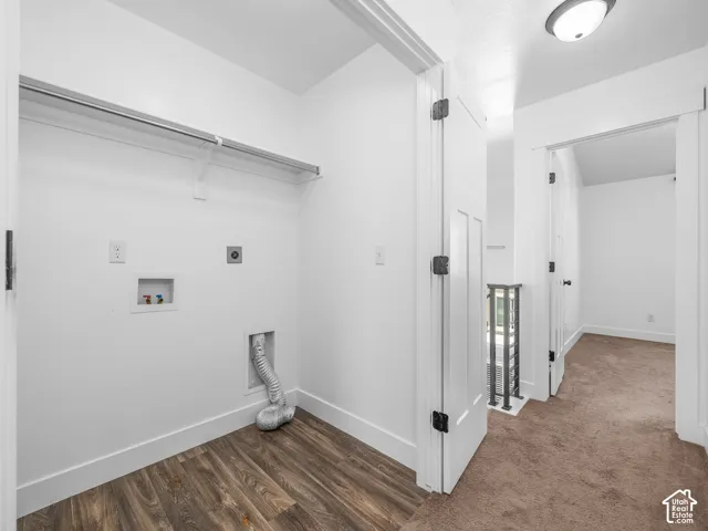 Dedicated laundry area with wood-finish flooring, featuring a clothes rod, and white walls