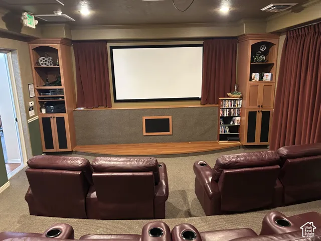 Club House - Dedicated media room featuring a large projection screen, tiered seating, built-in display cabinetry, and full-height drapery