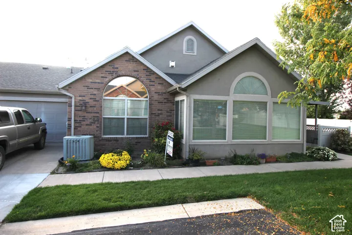 Brick and stucco exterior with an arched window and garage