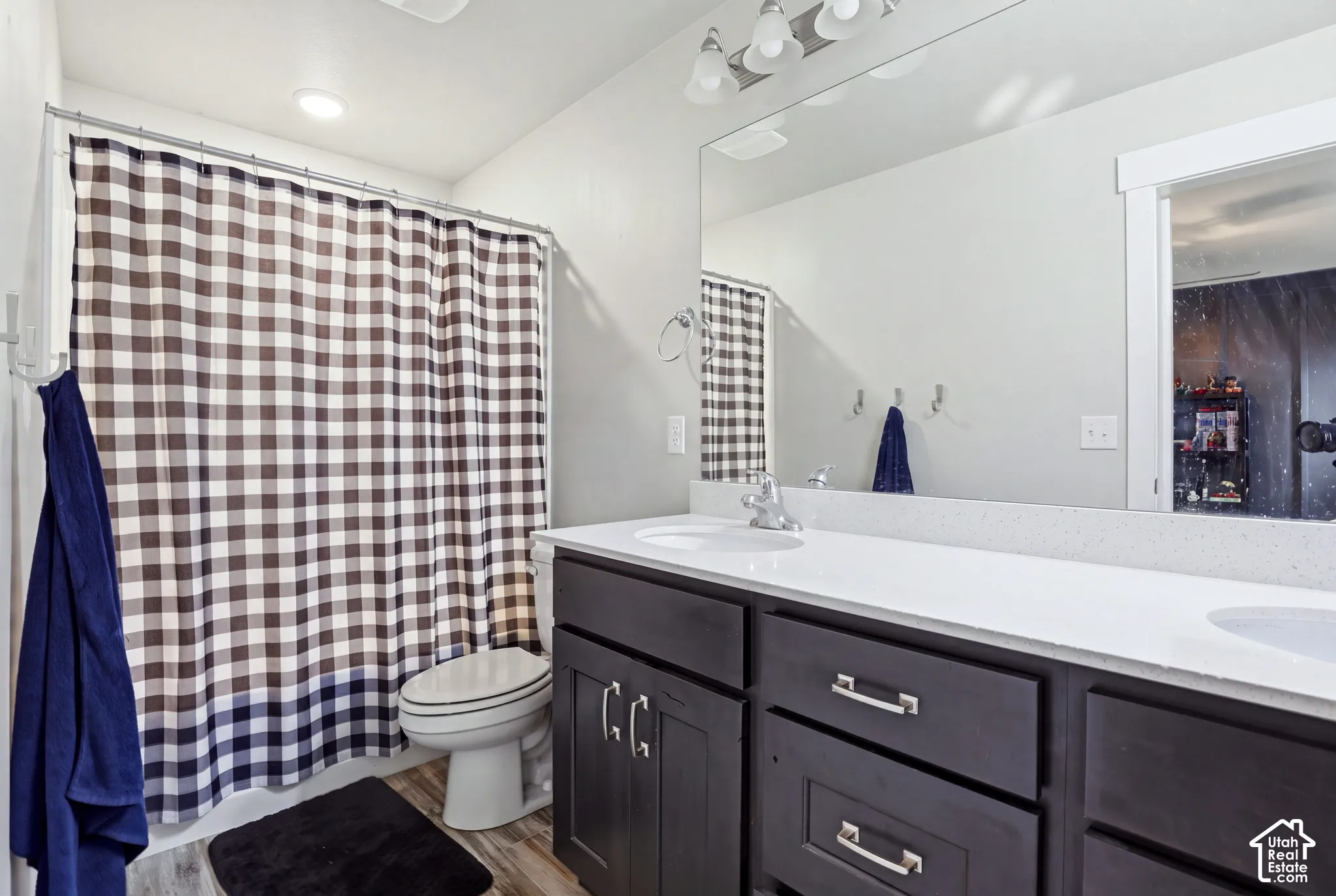 Dual vanity with white countertop, chrome fixtures, and dark wood-finish cabinetry
