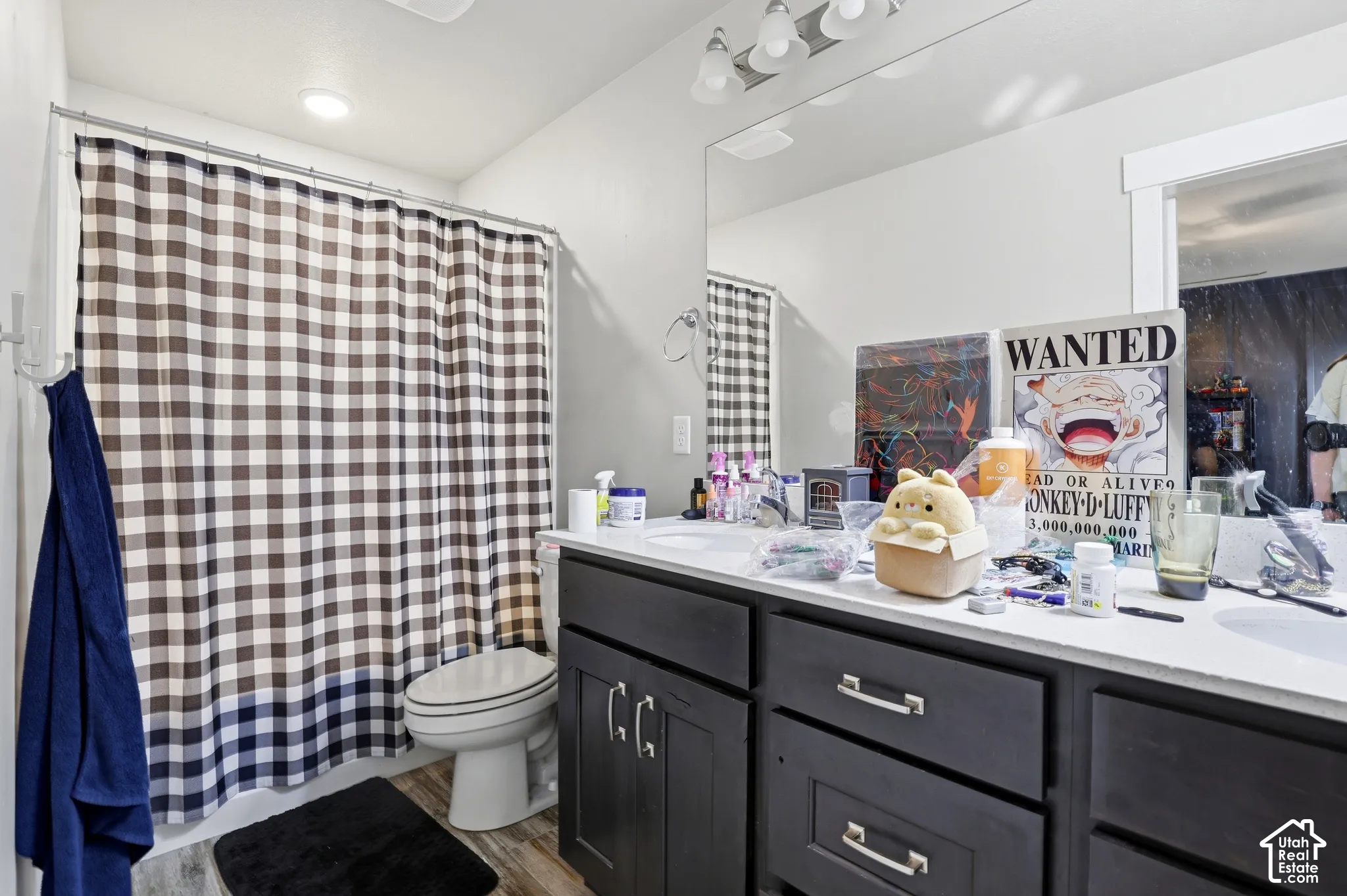 Vanity with dual sinks, dark cabinetry, and silver-tone hardware
