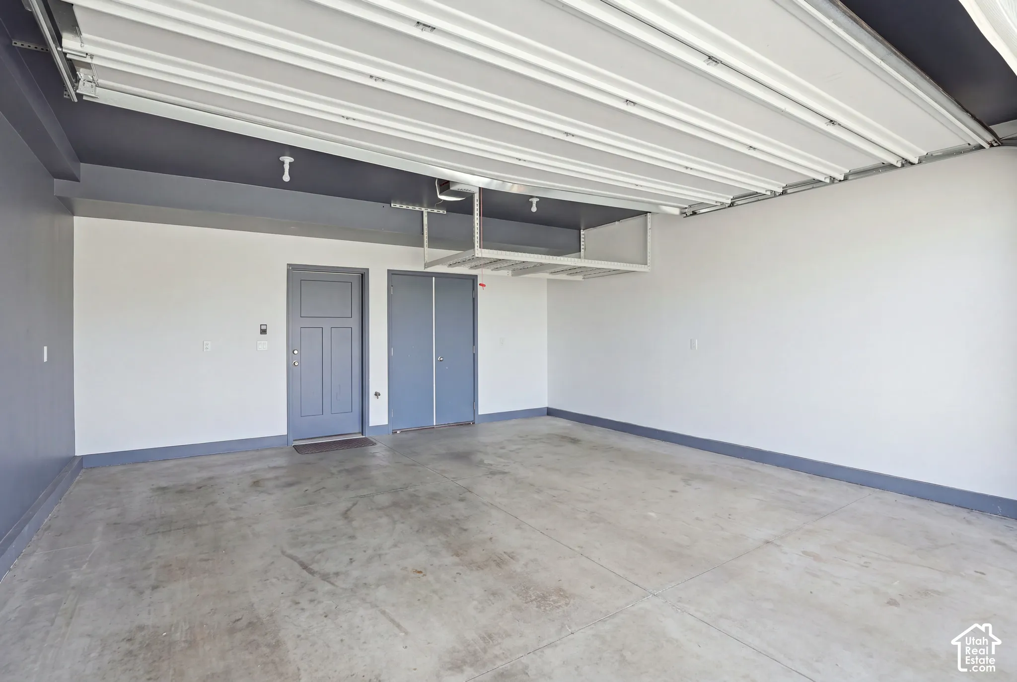 Concrete flooring, overhead storage racks, interior access door, utility closet