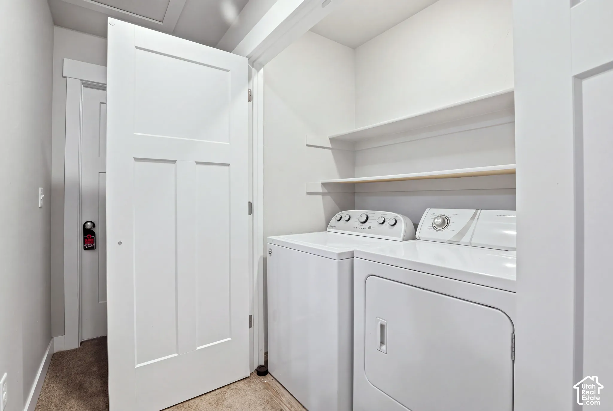 Laundry area with included appliances and two built-in shelves