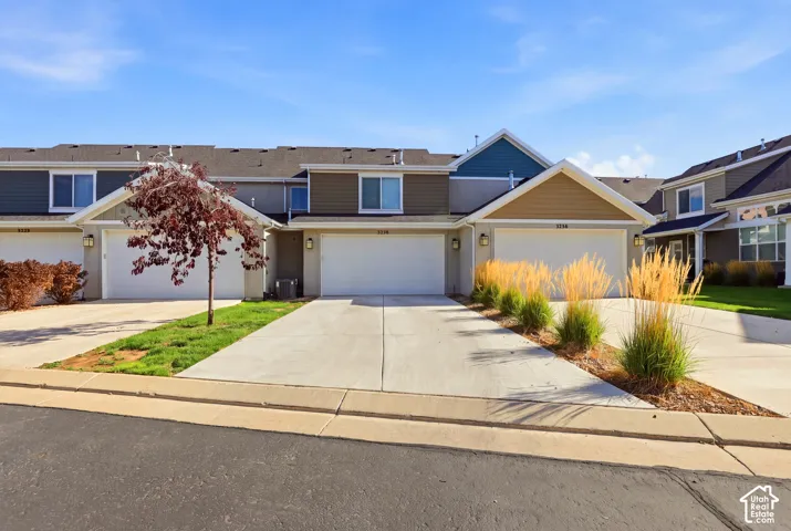 Townhome exterior featuring an attached two-car garage, concrete driveway, and a combination of siding and stucco finishes