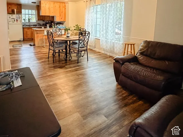 Wood-finish flooring throughout, with a dining area featuring a round table and wrought iron chairs