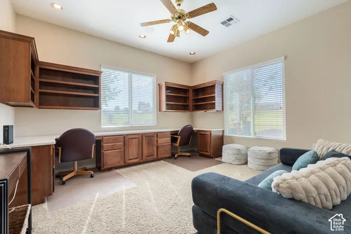 Built-in wood cabinetry with open shelving, integrated desk space, and recessed lighting