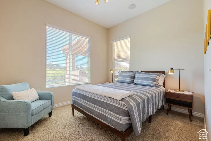 Vaulted ceiling, two windows, wall-to-wall carpeting, built-in ceiling speaker, and a ceiling-mounted light fixture