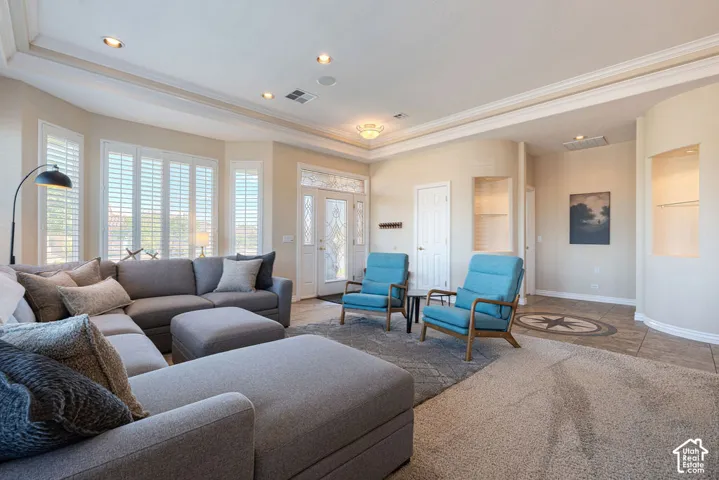 Recessed lighting illuminates the tray ceiling with crown molding