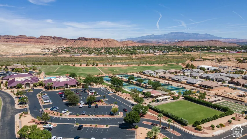 Expansive community featuring multiple tennis courts, a large green space, and numerous residential structures