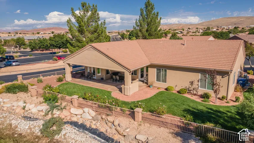 Covered patio, stucco exterior, tile roof, landscaped yard, paved patio