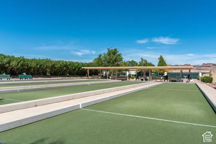 Multiple bocce ball courts with synthetic turf surfaces, bordered by concrete pathways