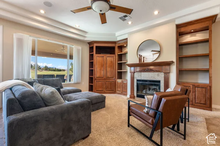 Recessed lighting, wood-finish ceiling fan, built-in wooden media center, fireplace with a tile surround and wood mantel, built-in wooden shelving units