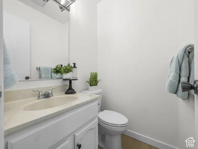 Vanity with an integrated sink and chrome faucet, white cabinetry with black hardware, and a wall-mounted mirror