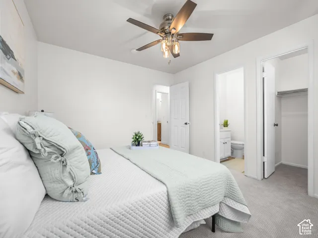 Neutral wall paint, ceiling fan with integrated lighting, soft grey carpeting, built-in closet with hanging rod, and white interior doors